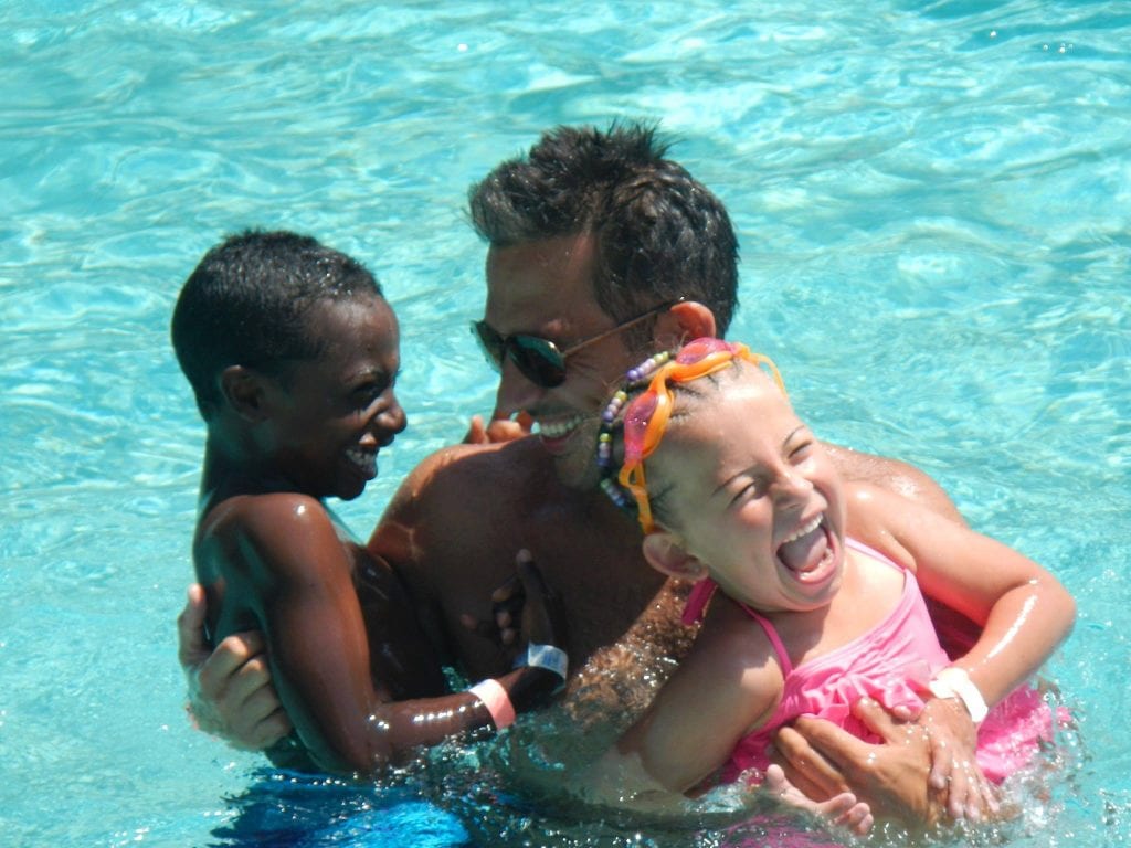 Transracial adoptive family laying in pool at Disney's Beach Club